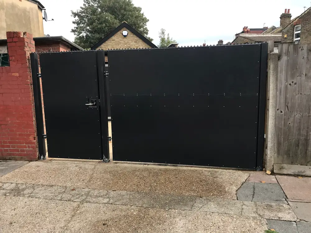 Black steel double gates hung between brick pillars